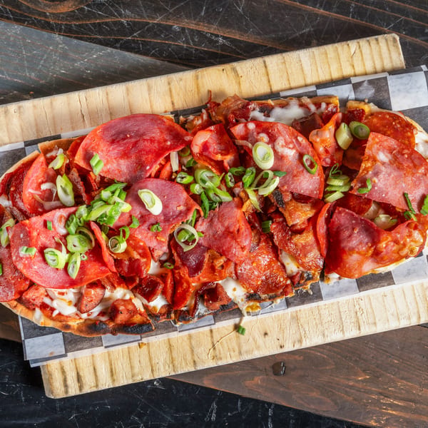R Bar's flatbread pizza, topped with pepperoni, salami, bacon, cheese, and green onions.