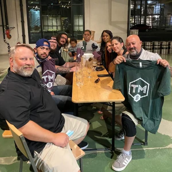 A group of people, including a child, sitting around a wooden table at R Bar.