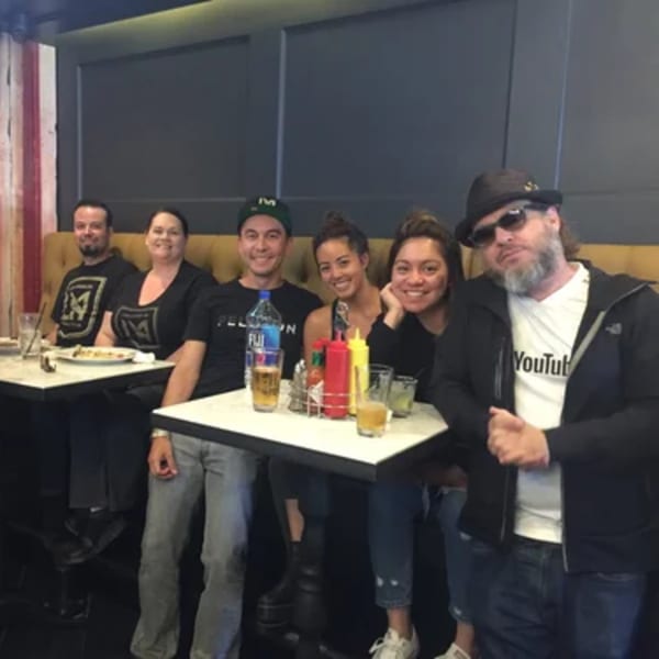 Six friends smiling and posing for a photo at a table in R Bar.