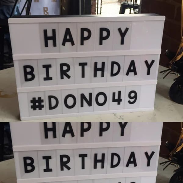 A white light-up sign at R Bar displays "HAPPY BIRTHDAY #DONO49" in black letters.